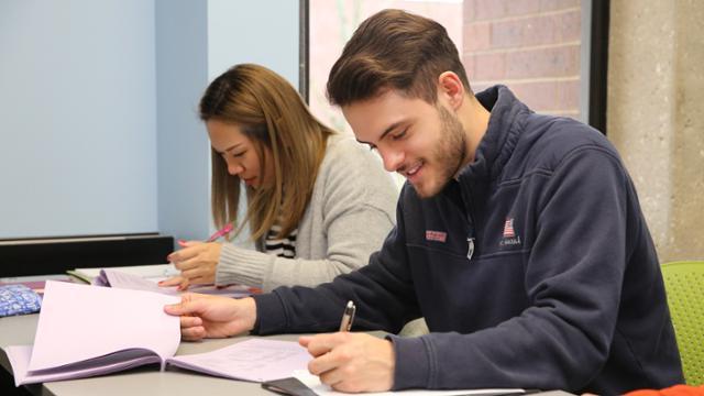 Two 赌钱app可以微信提现 students studying together at a table